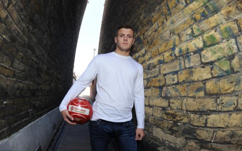 Image man in white crew neck long sleeve shirt holding white and red soccer ball