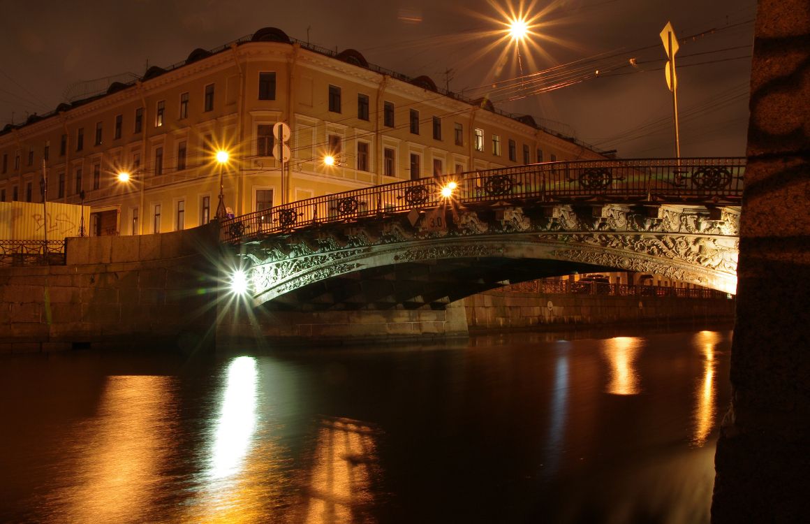 brown concrete building near bridge during night time