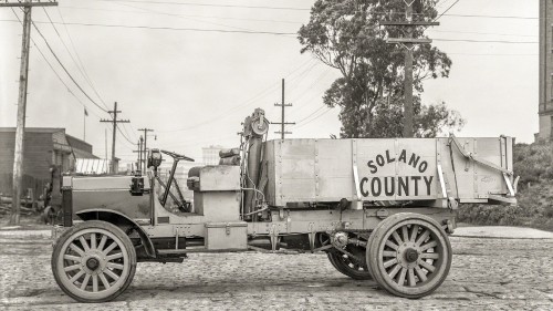 Image grayscale photo of a trailer truck parked near trees