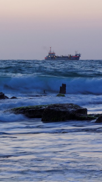 Image ocean waves crashing on rocks during daytime