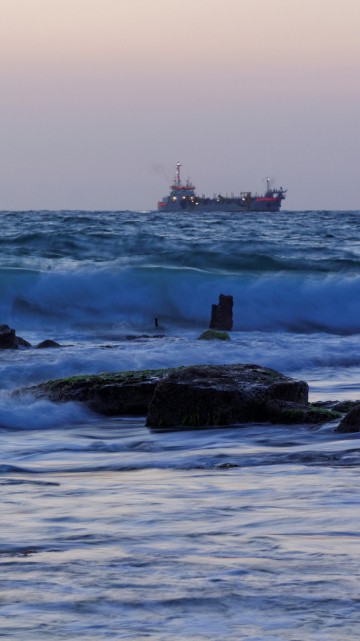 Image ocean waves crashing on rocks during daytime