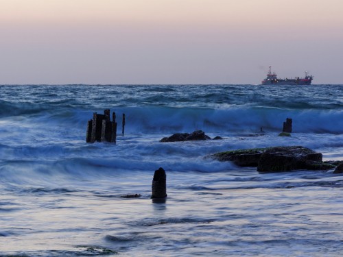 Image ocean waves crashing on rocks during daytime