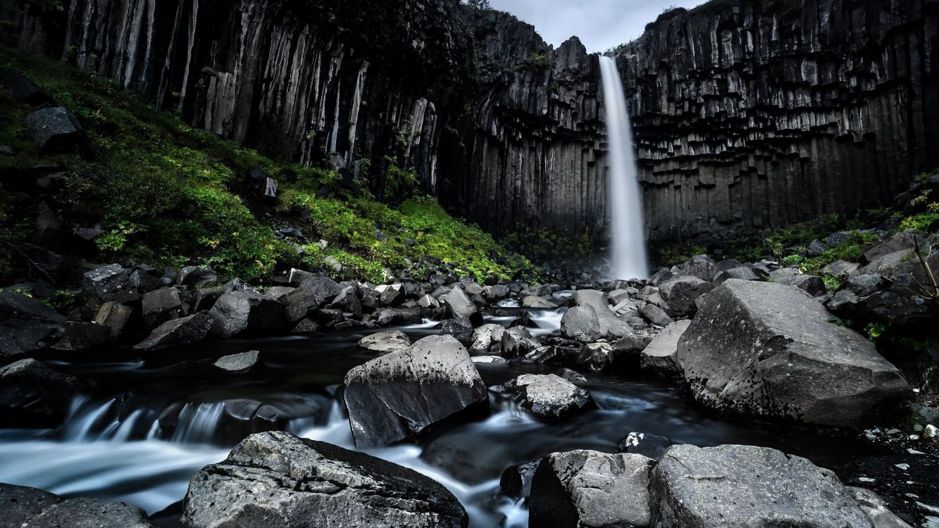 water falls in the middle of rocky mountains