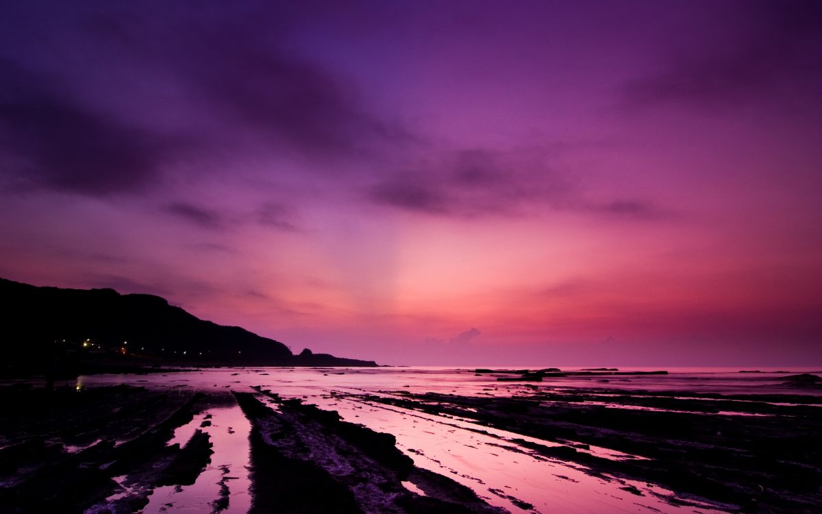 body of water under cloudy sky during sunset