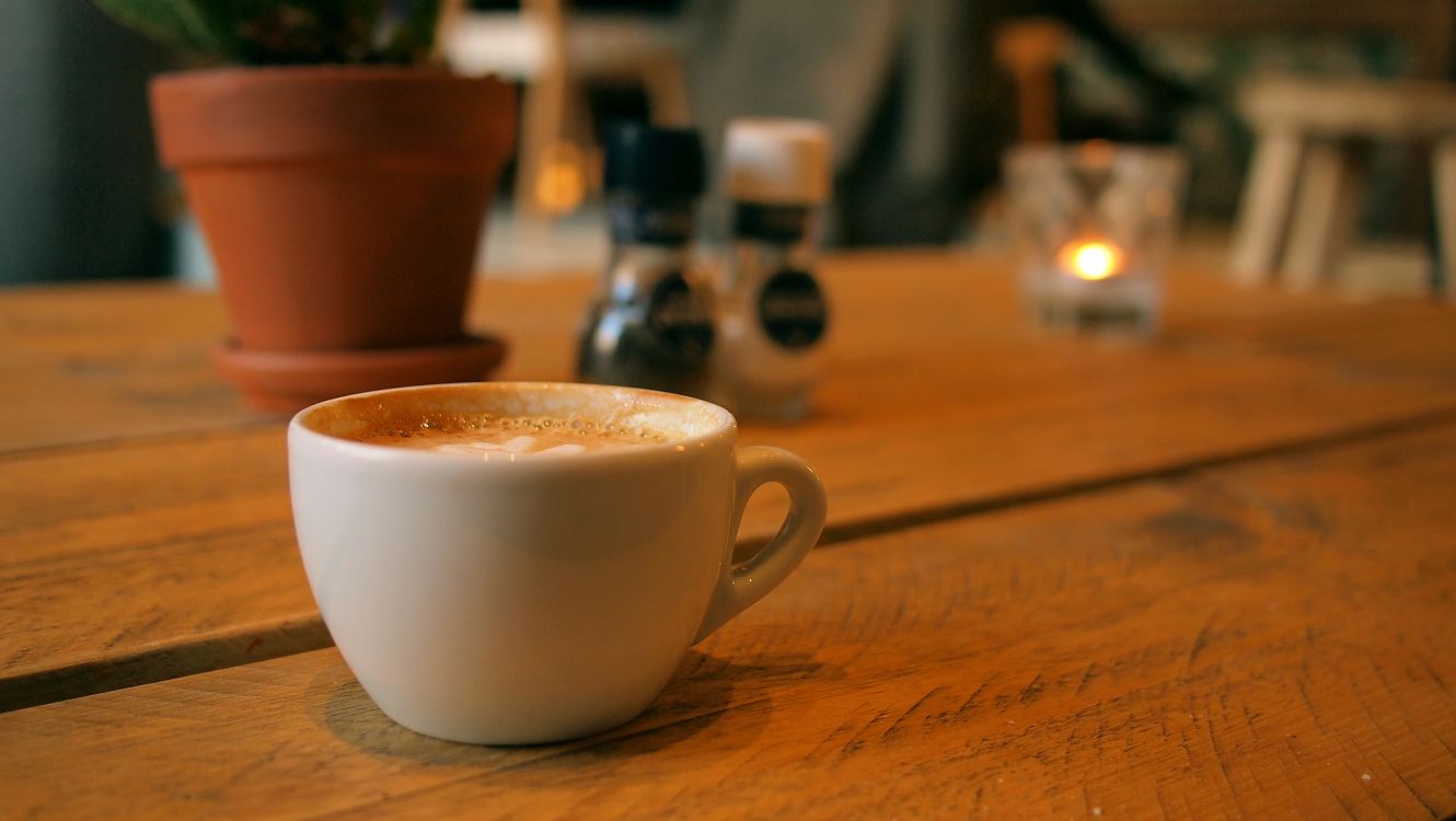 white ceramic mug on brown wooden table