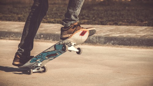 Image person in black pants and blue and white skateboard