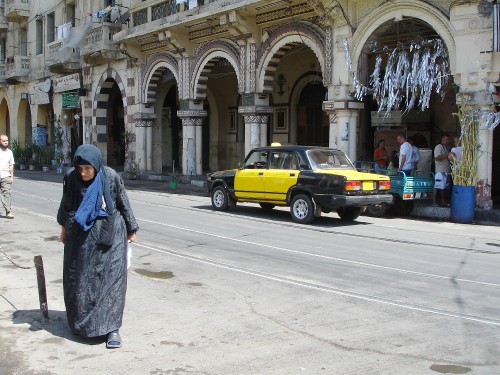 Image woman in gray coat walking on sidewalk during daytime