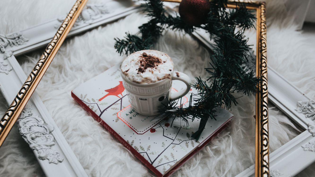 white ceramic mug on white and red book