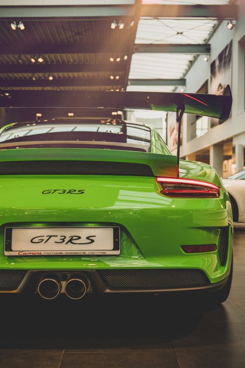 Green Porsche 911 Parked in Front of Building. Wallpaper in 4000x6000 Resolution