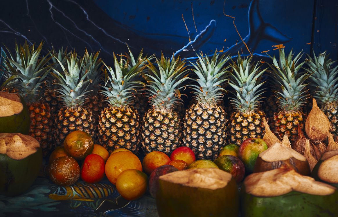 pineapple and orange fruits on brown wooden table