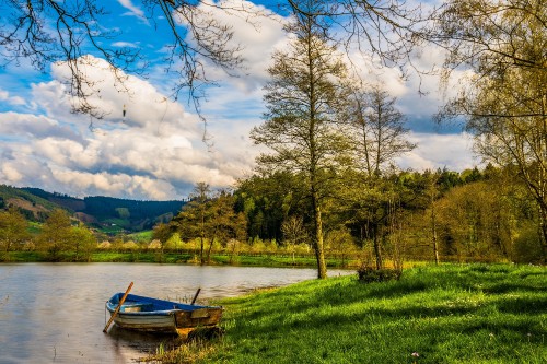 Image brown boat on green grass field near lake during daytime