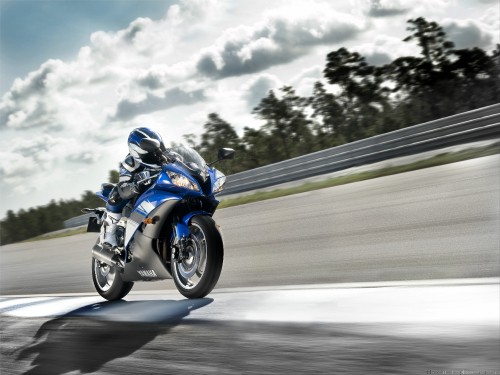 Image man in blue and white jacket riding blue and white sports bike