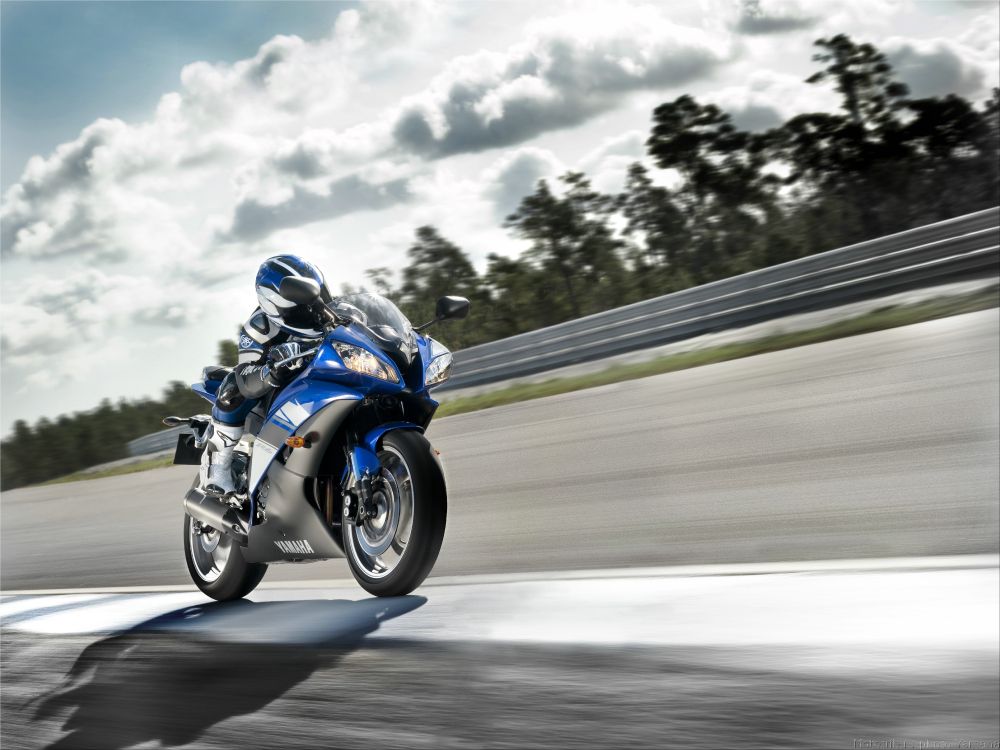 man in blue and white jacket riding blue and white sports bike