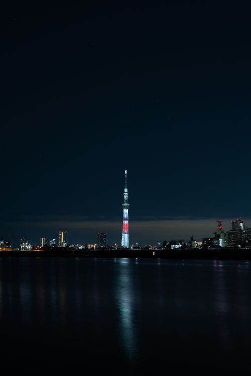 White and Red Tower Near Body of Water During Night Time. Wallpaper in 4000x6000 Resolution