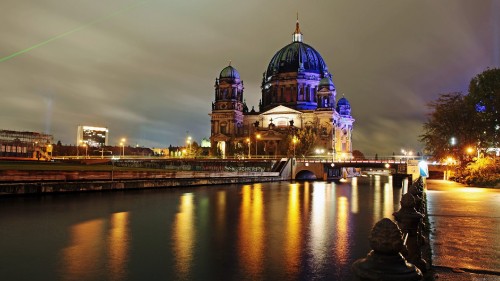 Image blue and brown dome building near body of water during night time