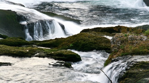 Image water falls on brown and green rock