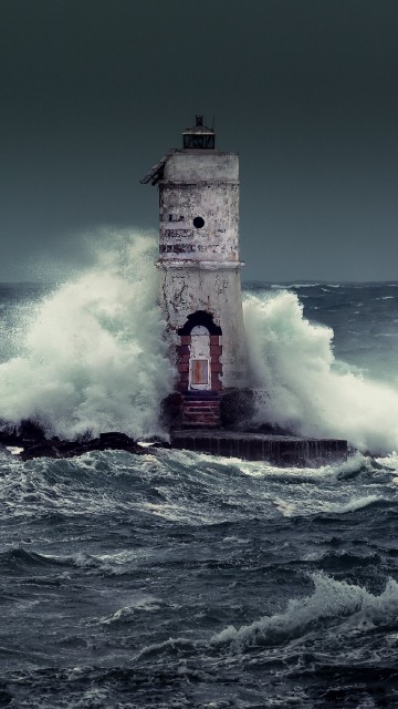 Image brown and white concrete building on sea waves during daytime