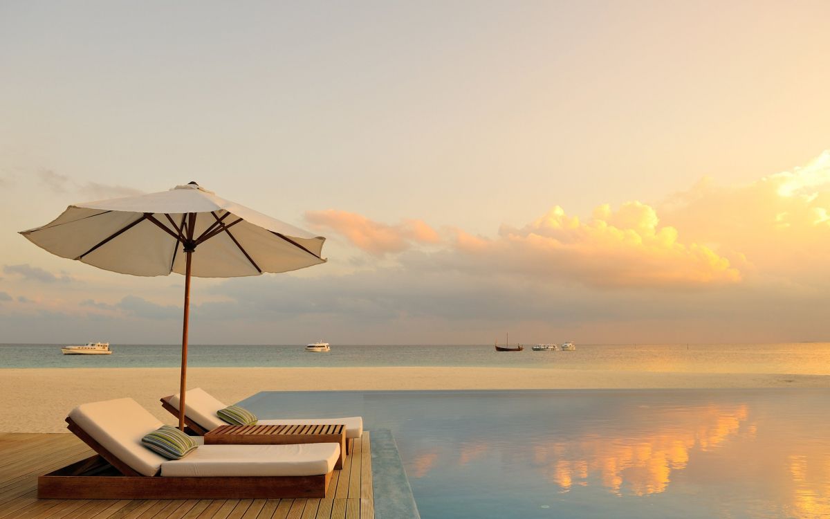 white and brown wooden lounge chairs on beach during daytime