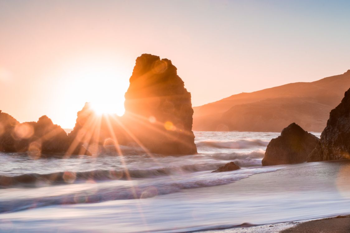 brown rock formation on sea during daytime