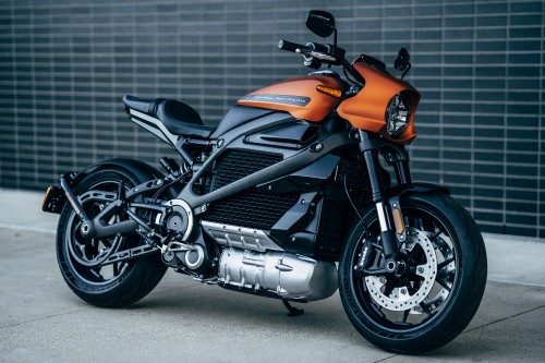 Image orange and black motorcycle on gray pavement