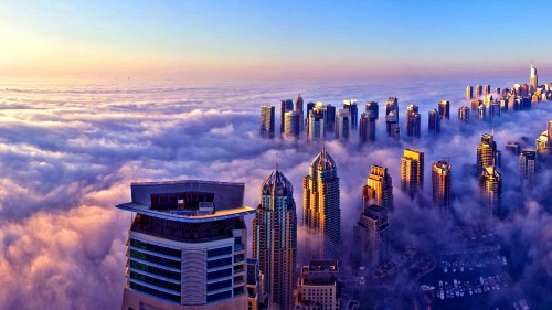 Image high rise building under white clouds during daytime