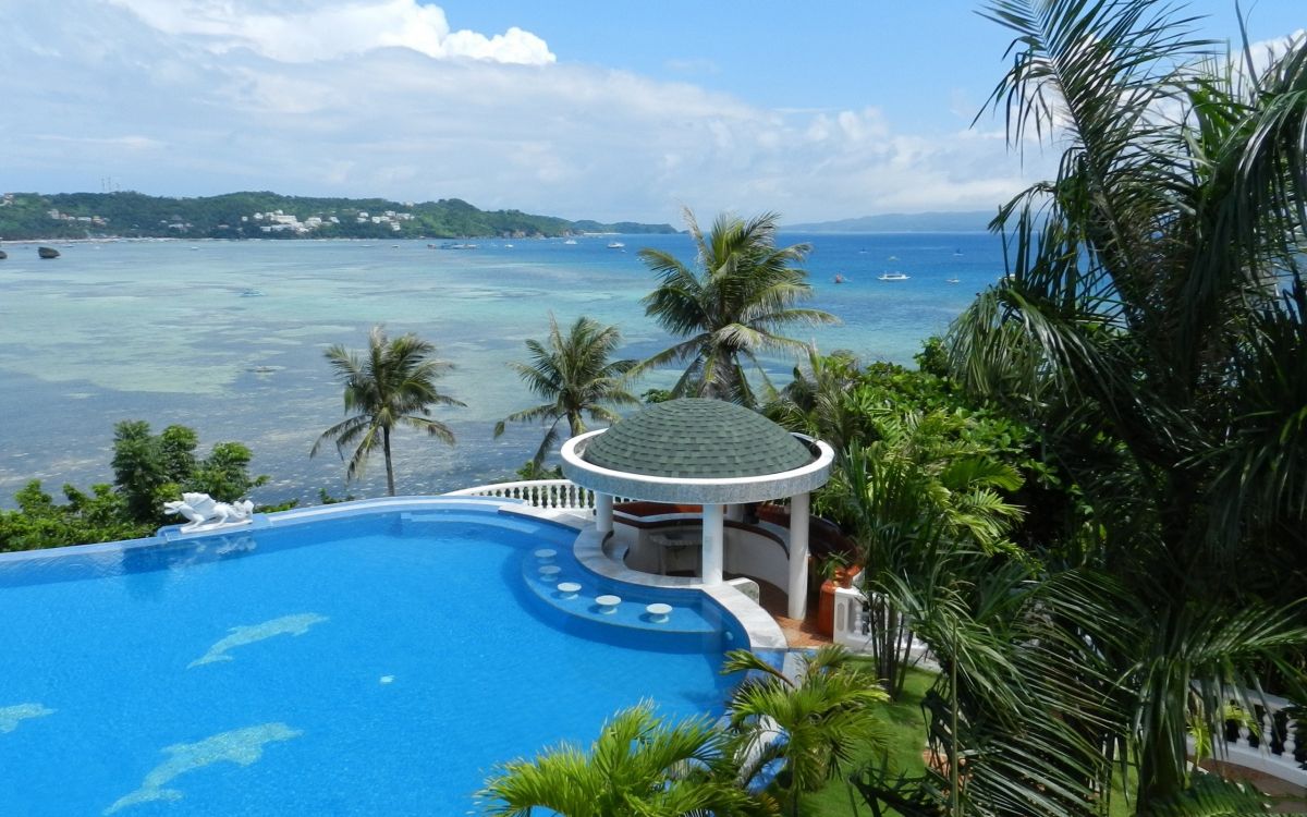 white and blue swimming pool near green palm trees during daytime