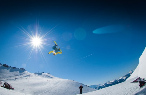 Image person in black jacket and yellow pants on snow covered mountain during daytime