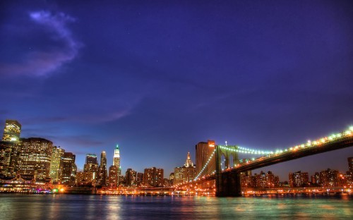 Image lighted bridge over water during night time