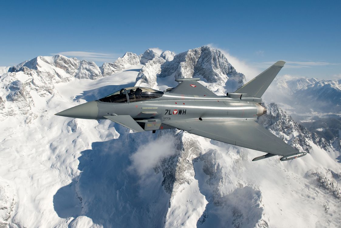 Grauer Kampfjet, Der Tagsüber Über Schneebedeckte Berge Fliegt. Wallpaper in 6990x4668 Resolution