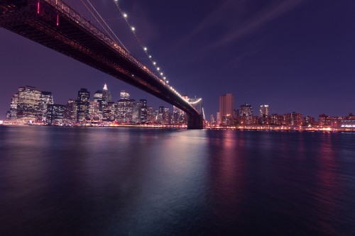 Image lighted bridge over body of water during night time