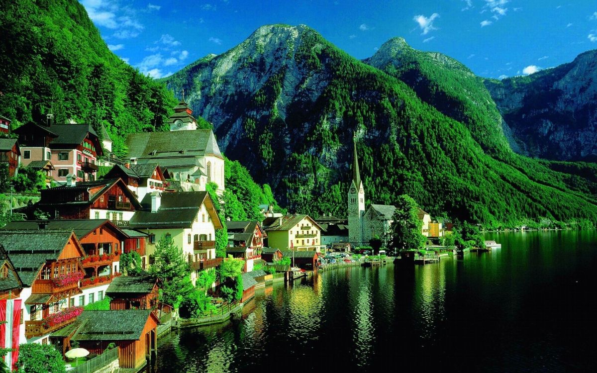 houses near lake and mountain during daytime