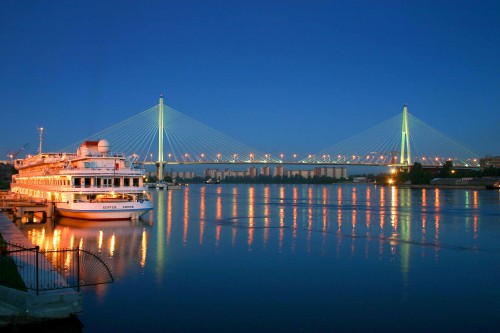 Image white and brown boat on body of water near bridge during daytime