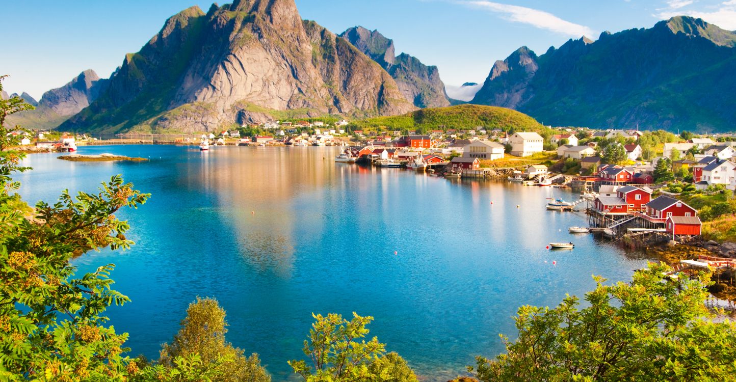 houses near lake and mountain during daytime