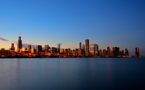 Image city skyline across body of water during daytime