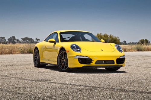 Image yellow porsche 911 on grey concrete road during daytime