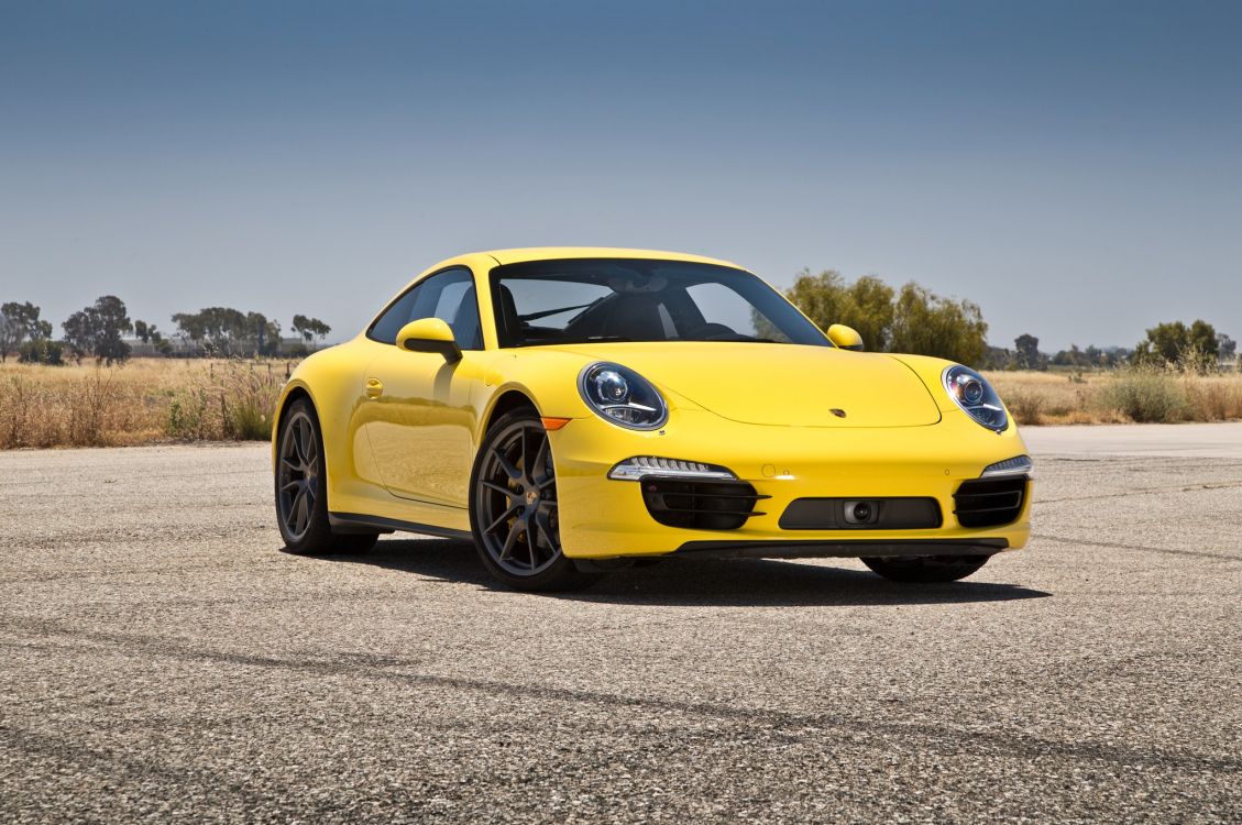 yellow porsche 911 on grey concrete road during daytime