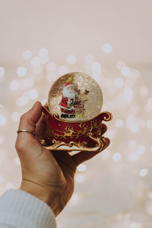 Image person holding white and red christmas bauble