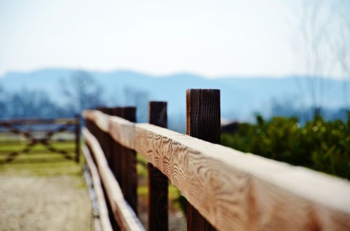 Image brown wooden fence on green grass field during daytime