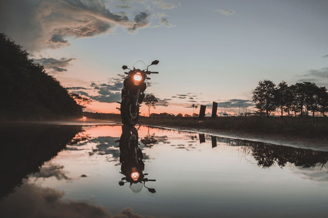 Man Riding Bicycle Sur le Lac Pendant le Coucher du Soleil. Wallpaper in 5472x3648 Resolution