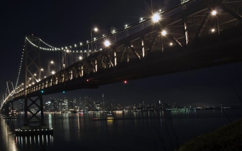 Image lighted bridge over body of water during night time