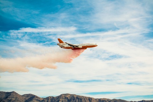 Image white and orange airplane flying over the mountains during daytime