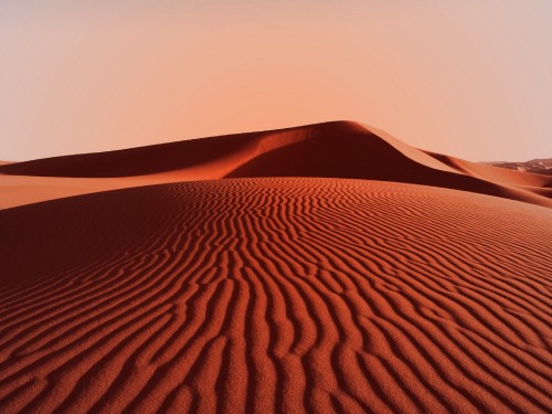 Image brown sand dunes under white sky during daytime