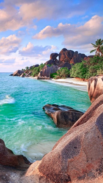 Image brown rock formation near body of water during daytime