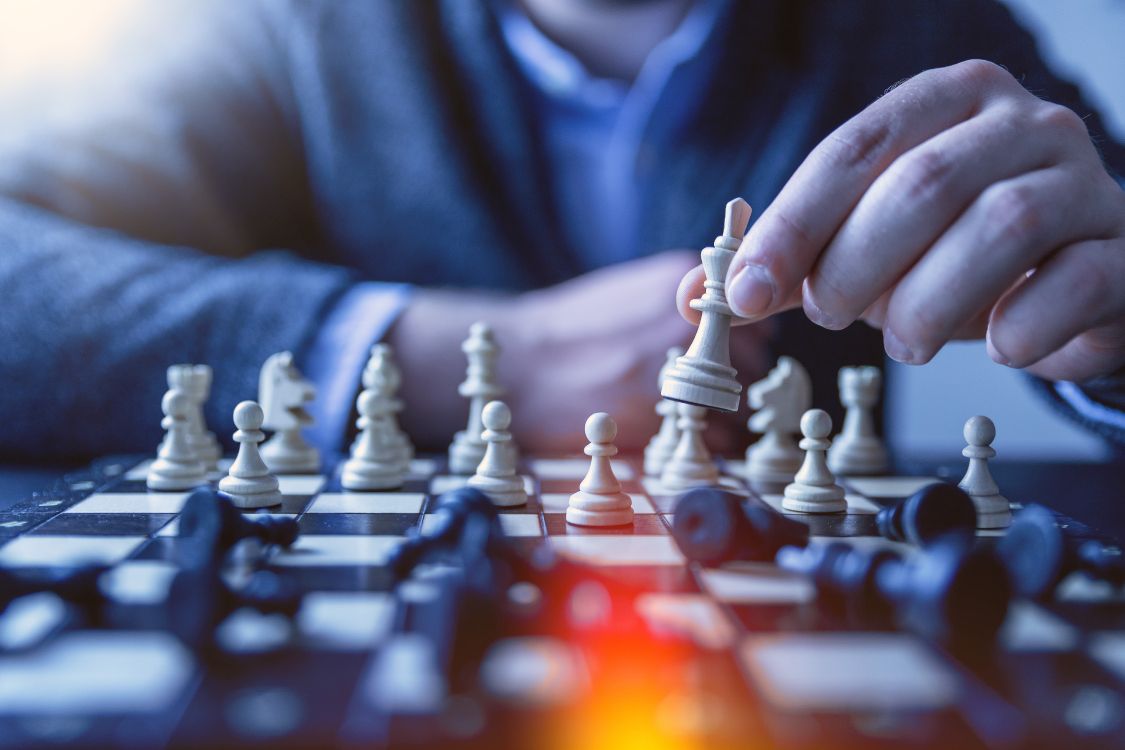 person holding chess piece in tilt shift lens