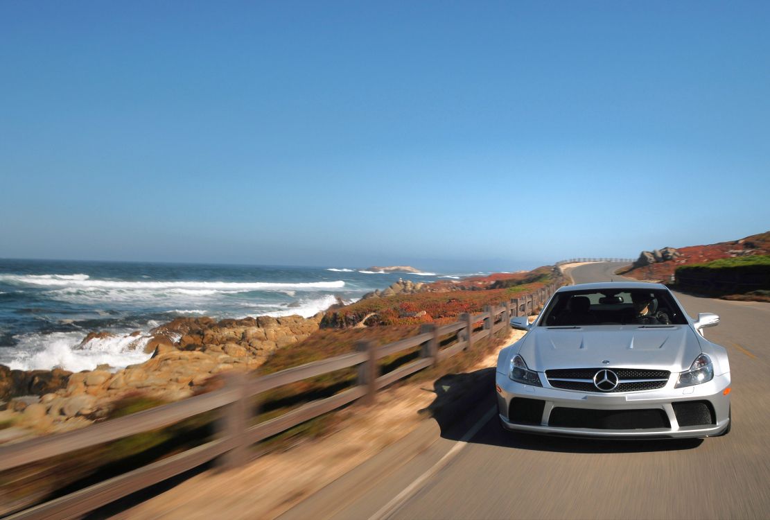 white car on road near sea during daytime