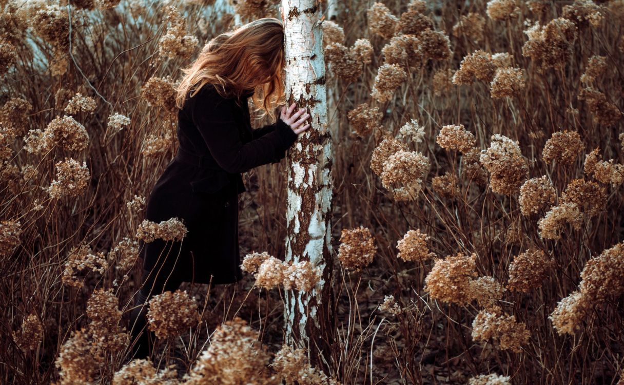 woman in black long sleeve shirt standing on brown grass field during daytime