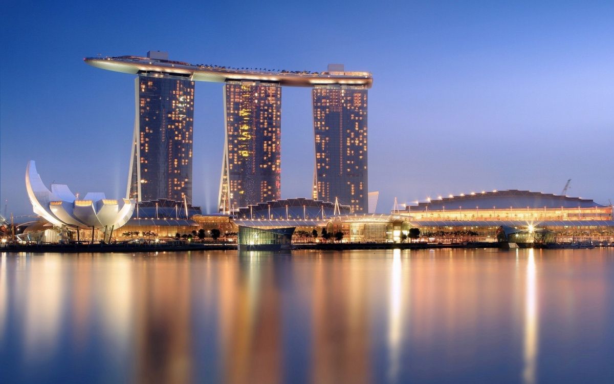 city skyline across body of water during night time