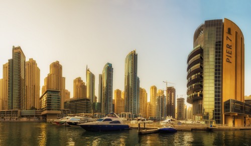 Image white and blue boat on body of water near city buildings during daytime