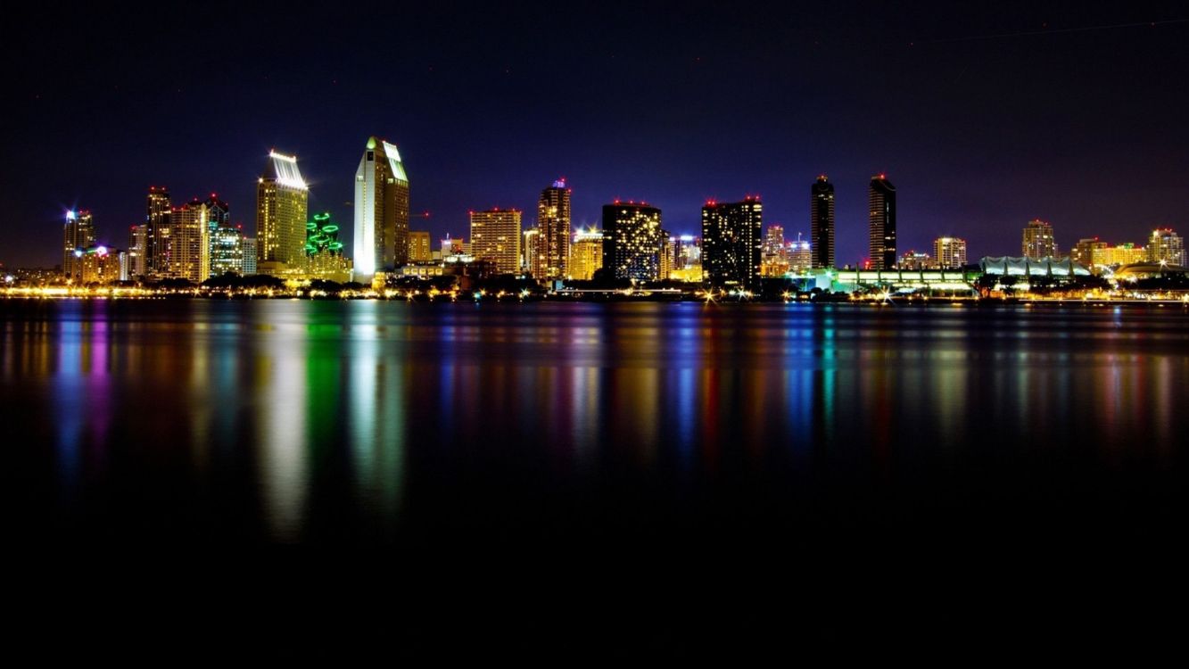 City Skyline Across Body of Water During Night Time. Wallpaper in 2560x1440 Resolution
