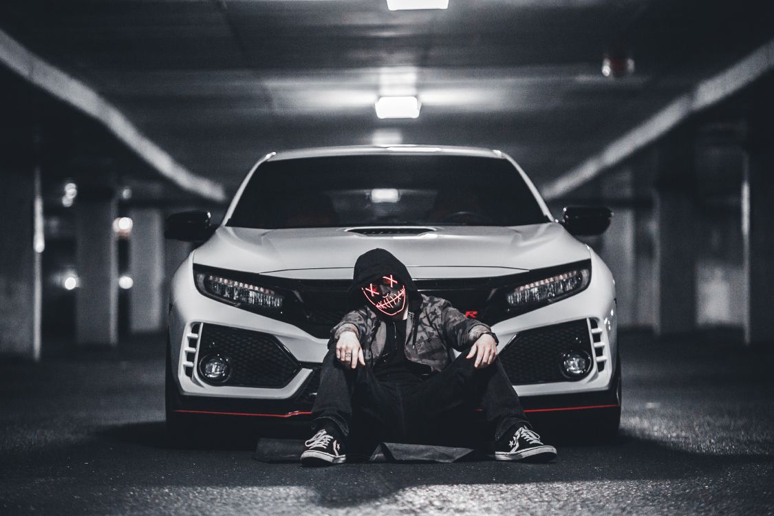 man in black jacket and black pants sitting on white mercedes benz car